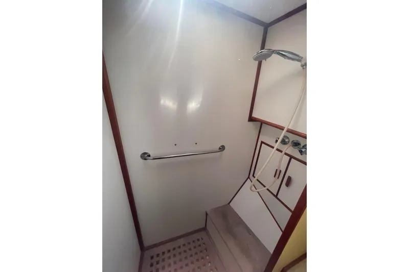 Slide: The Image of Shower area in 1990 Grand Banks 46 Classic yacht, featuring a handheld showerhead and grab bar. - 15