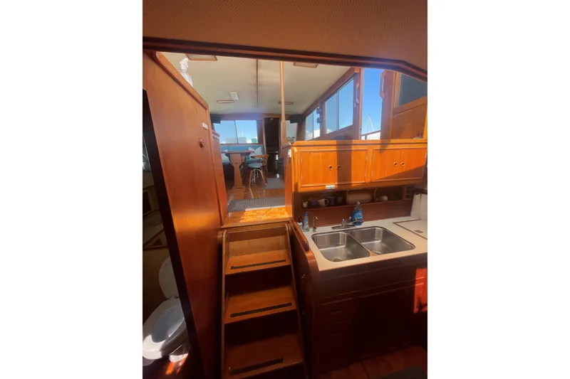 Slide: The Image of Interior of 1990 Grand Banks 46 Classic yacht, featuring wooden cabinetry and a compact kitchen. - 7