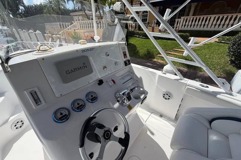 Slide: The Image of 2008 Donzi 29 ZF Cuddy boat cockpit with Garmin navigation system and steering wheel. - 11
