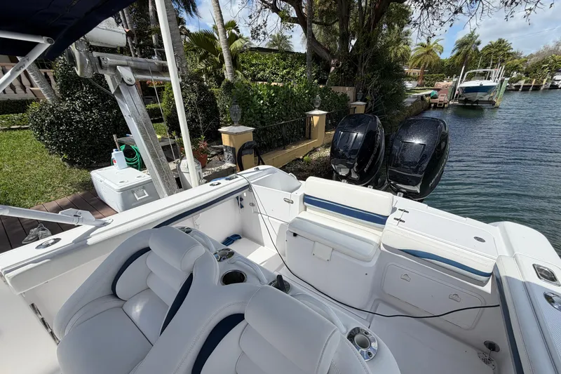 Slide: The Image of 2008 Donzi 29 ZF Cuddy boat with dual engines docked by a lush canal. - 12