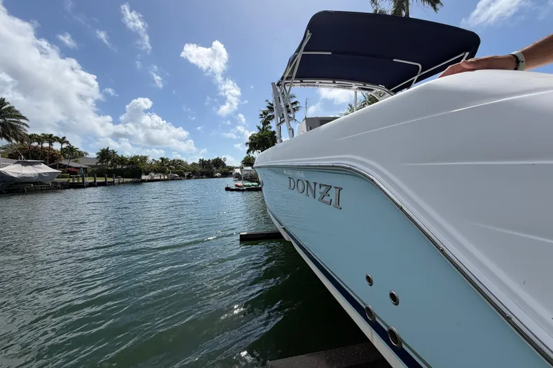 Slide: The Image of 2008 Donzi 29 ZF Cuddy boat docked on a sunny waterfront. - 18