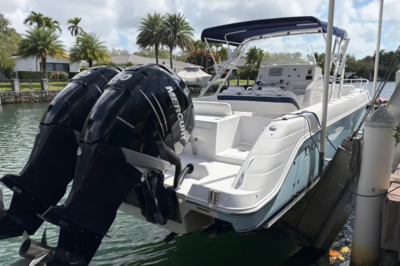 Slide: The Image of 2008 Donzi 29 ZF Cuddy boat with twin Mercury engines docked by palm trees. - 5