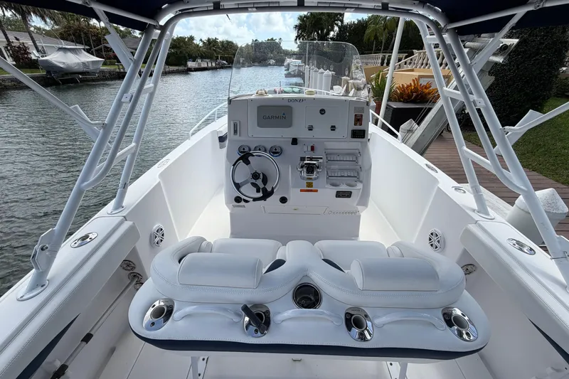 Slide: The Image of 2008 Donzi 29 ZF Cuddy boat interior with steering console and seating, docked by a canal. - 7