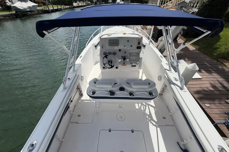 Slide: The Image of 2008 Donzi 29 ZF Cuddy boat interior with helm and seating, docked by the water. - 8