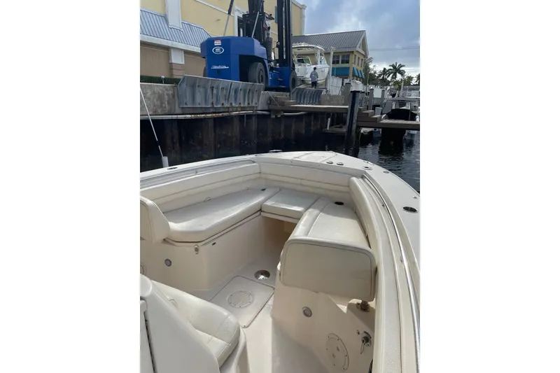 Slide: The Image of 2023 Grady-White Canyon 306 boat interior at marina, showcasing seating and dockside view. - 13