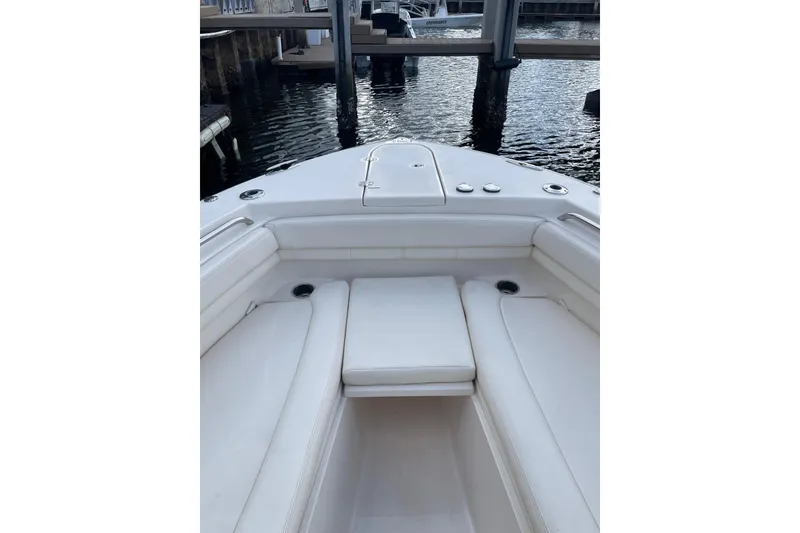 Slide: The Image of 2023 Grady-White Canyon 306 boat interior with white seating, docked by the water. - 14