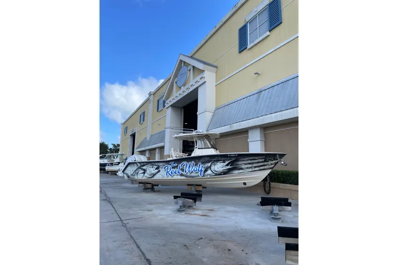 Slide: The Image of 2023 Grady-White Canyon 306 boat with custom "Reel Wolf" design outside a building. - 22