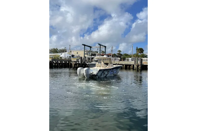 Slide: The Image of 2023 Grady-White Canyon 306 boat docked in a marina under a cloudy sky. - 3