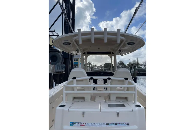 Slide: The Image of 2023 Grady-White Canyon 306 boat interior with seating and helm, docked under cloudy sky. - 5