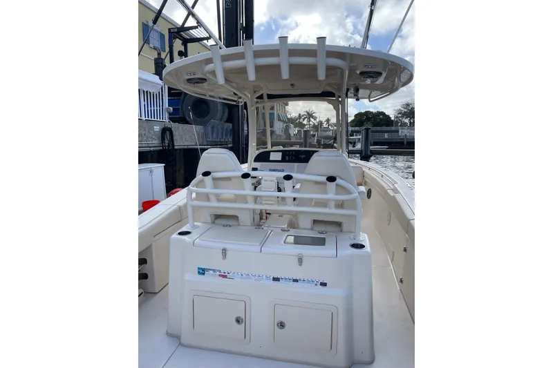 Slide: The Image of 2023 Grady-White Canyon 306 boat interior with helm and seating, docked by the water. - 6