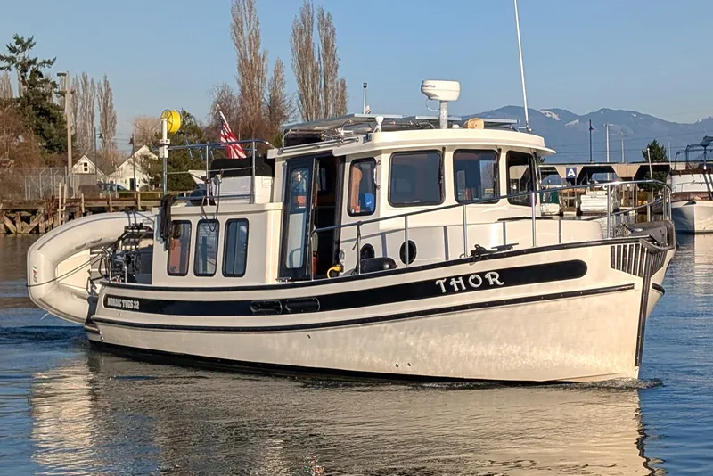 The Image of 2002 Nordic Tug 32 boat named "Thor" cruising on calm waters. - 0