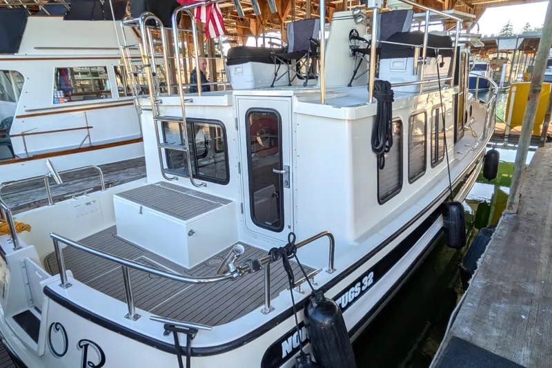 Slide: The Image of 2002 Nordic Tug 32 docked, featuring spacious deck and classic design. - 15