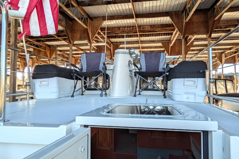Slide: The Image of 2002 Nordic Tug 32 boat deck with chairs and American flag in marina. - 16