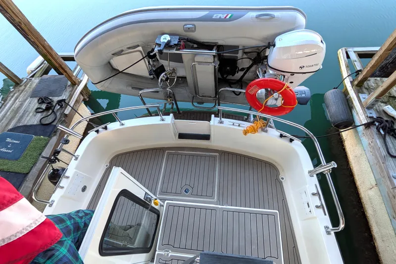 Slide: The Image of 2002 Nordic Tug 32 with dinghy and Tohatsu motor at dock. - 17