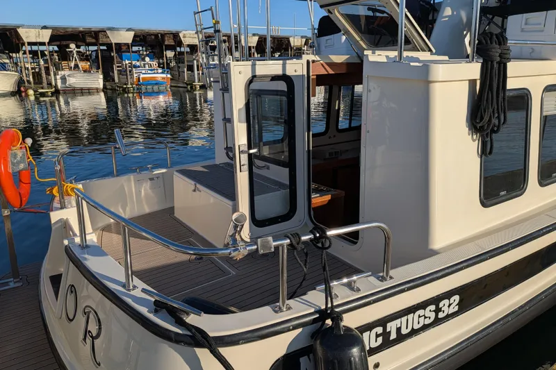 Slide: The Image of Nordic Tug 32, 2002 model, docked at marina with open cabin door. - 24