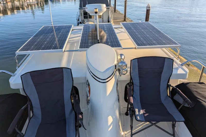 Slide: The Image of Nordic Tug 32 (2002) with solar panels and chairs on deck by the water. - 28