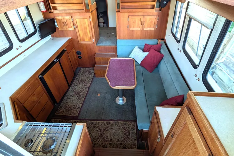 Slide: The Image of Interior of a 2002 Nordic Tug 32 with cozy seating and wooden cabinetry. - 30