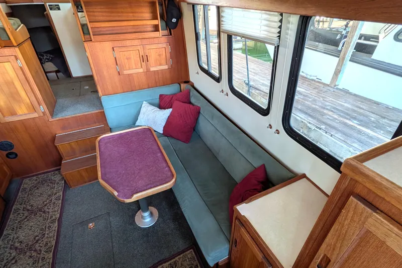 Slide: The Image of Cozy interior of 2002 Nordic Tug 32 with seating, table, and wood accents. - 33
