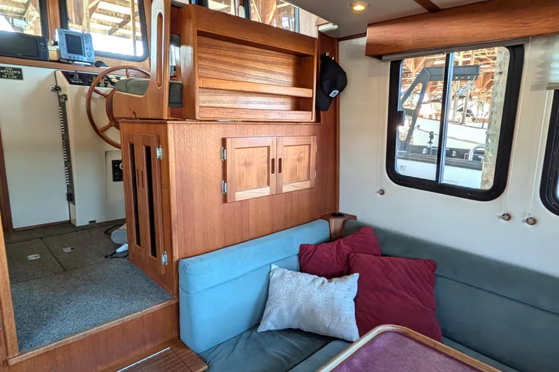Slide: The Image of Interior of 2002 Nordic Tug 32 with wooden helm, seating, and windows. - 36