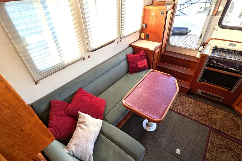 Slide: The Image of Interior of 2002 Nordic Tug 32 with cozy seating, table, and kitchen area. - 41