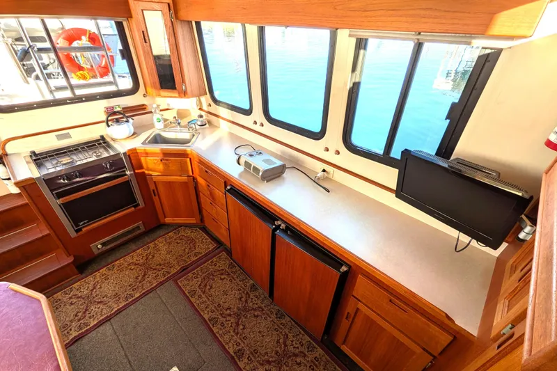 Slide: The Image of Cozy kitchen interior of 2002 Nordic Tug 32 with wooden cabinetry and appliances. - 42