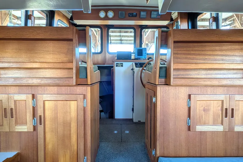 Slide: The Image of Interior of a 2002 Nordic Tug 32, featuring wooden cabinetry and navigation equipment. - 43