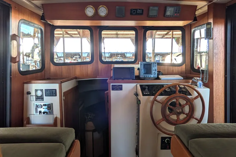 Slide: The Image of 2002 Nordic Tug 32 boat interior with wooden helm and navigation equipment. - 45