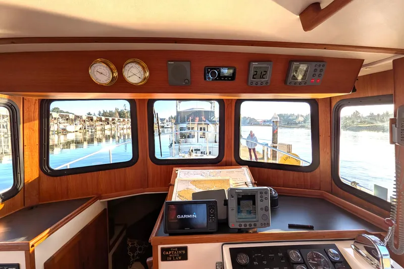 Slide: The Image of Pilothouse interior of 2002 Nordic Tug 32 with navigation equipment and scenic marina view. - 46