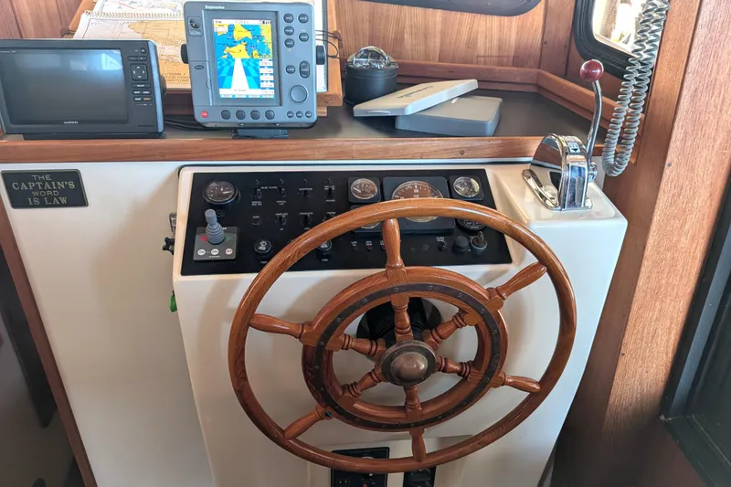 Slide: The Image of Nordic Tug 32 helm with wooden wheel, navigation equipment, and control panel, 2002 model. - 48