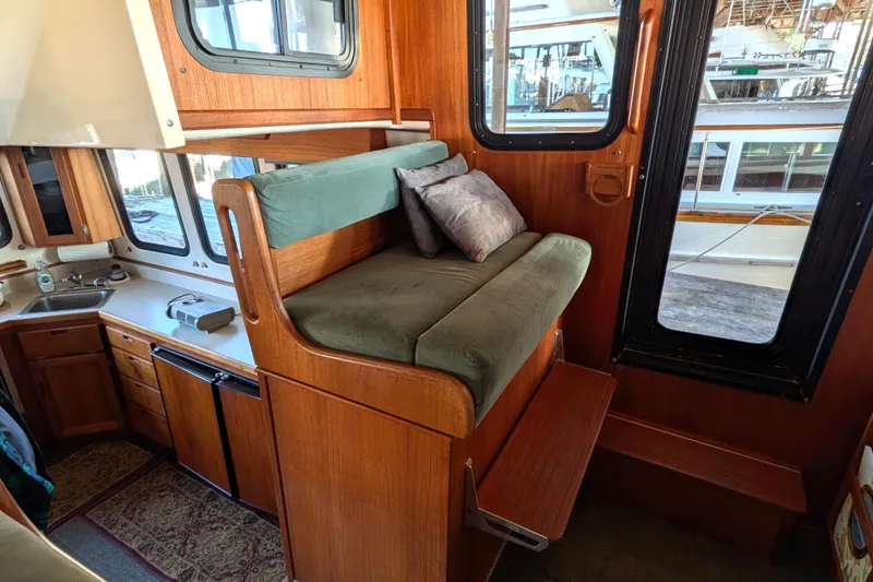 Slide: The Image of Interior of a 2002 Nordic Tug 32, featuring a cozy seating area and kitchenette. - 52