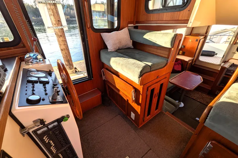 Slide: The Image of Cozy interior of a 2002 Nordic Tug 32, featuring helm and seating area. - 56