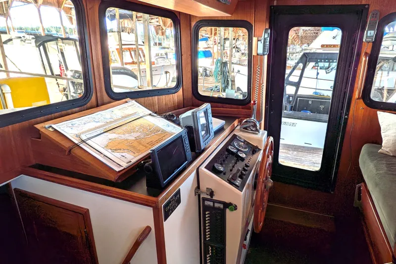 Slide: The Image of Interior of a 2002 Nordic Tug 32, featuring navigation equipment and a steering wheel. - 57