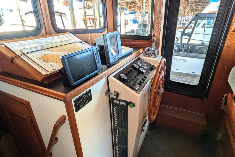 Slide: The Image of Pilothouse of 2002 Nordic Tug 32 with navigation equipment and wooden steering wheel. - 58
