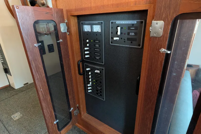 Slide: The Image of Electrical panel inside a 2002 Nordic Tug 32 boat, featuring switches and meters. - 70