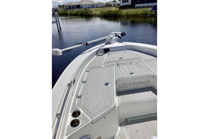 Slide: The Image of 2019 Crevalle 26 Bay boat deck with fishing rod holders and trolling motor. - 4