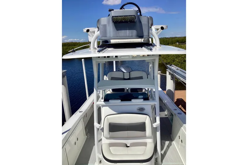 Slide: The Image of 2019 Crevalle 26 Bay boat with dual seating and helm, docked by the water. - 5