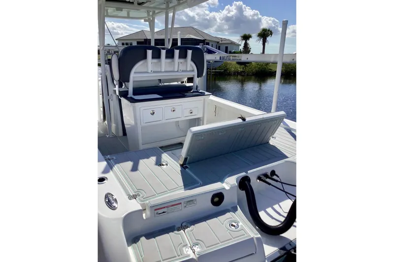 Slide: The Image of 2019 Crevalle 26 Bay boat interior with storage compartments and seating, near water. - 6