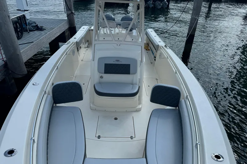 Slide: The Image of 2018 Cobia 301 Center Console boat docked, featuring spacious seating and sleek design. - 16