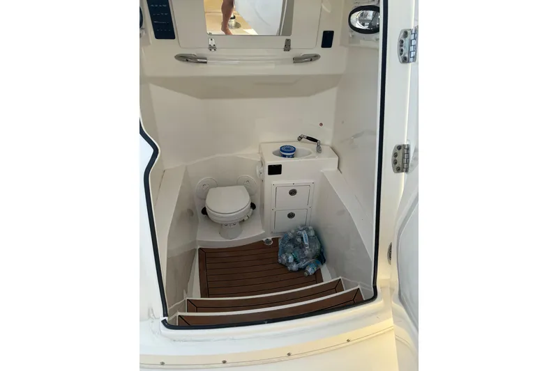 Slide: The Image of 2018 Cobia 301 Center Console boat interior with toilet and sink. - 17