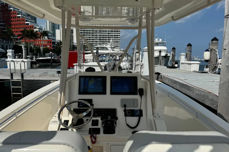 Slide: The Image of 2018 Cobia 301 Center Console boat at marina with cityscape background. - 19