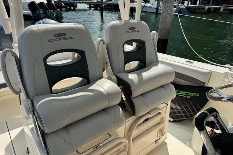 Slide: The Image of 2018 Cobia 301 Center Console boat seats, docked by the water. - 20