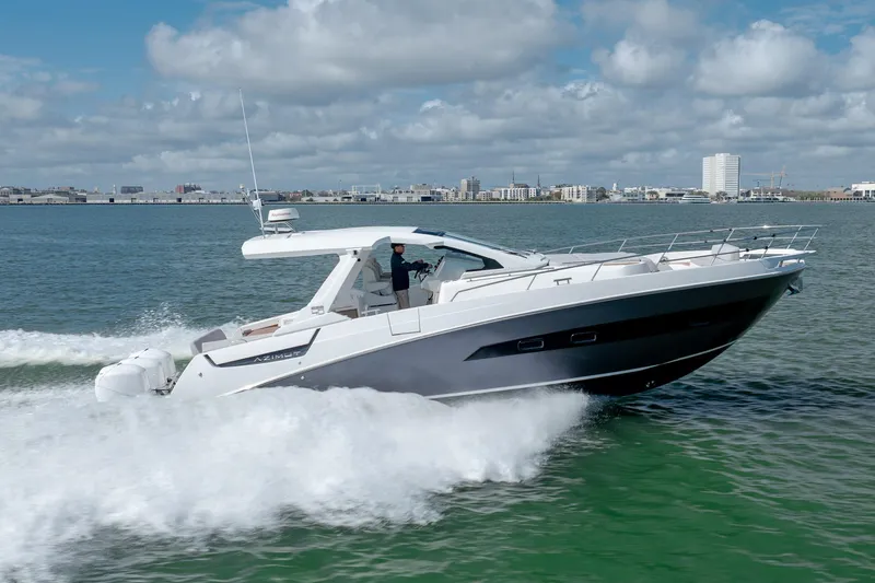 Slide: The Image of 2019 Azimut Verve 40 yacht cruising on open water, city skyline in background. - 3