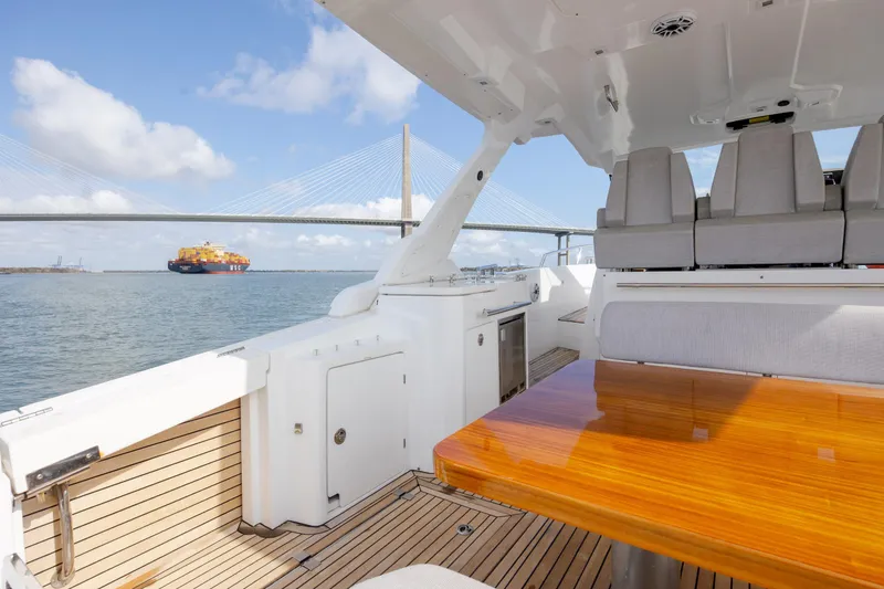 Slide: The Image of 2019 Azimut Verve 40 yacht interior with wooden table, ocean view, and bridge in background. - 31