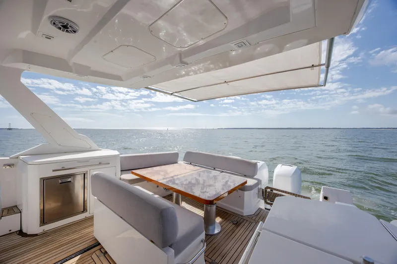 Slide: The Image of 2019 Azimut Verve 40 yacht deck with seating, table, and ocean view. - 42