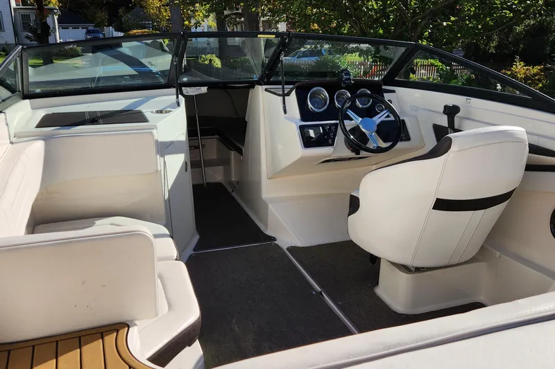 Slide: The Image of 2019 Sea Ray SPX 190 Outboard interior with white seating and modern dashboard. - 10