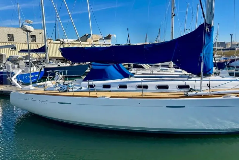 Slide: The Image of 2003 Beneteau First 47.7 sailboat docked in marina, featuring blue sail covers. - 3