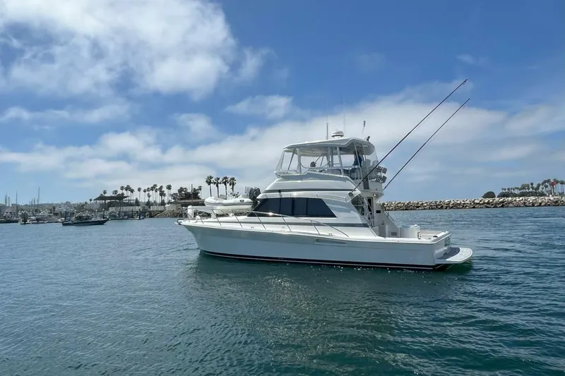 Slide: The Image of 2002 Riviera 43 Open Flybridge yacht on calm water, clear sky background. - 19
