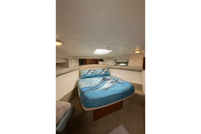 Slide: The Image of Interior of 2002 Riviera 43 Open Flybridge with cozy bed and marine-themed bedding. - 8