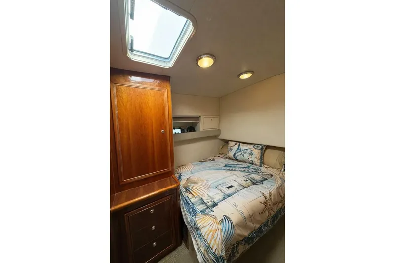 Slide: The Image of Cozy bedroom in 2002 Riviera 43 Open Flybridge yacht with nautical-themed bedding. - 9
