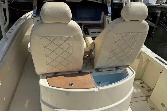 Slide: The Image of 2018 Chris-Craft Catalina 30 boat interior with beige diamond-stitched seats and wooden accents. - 11